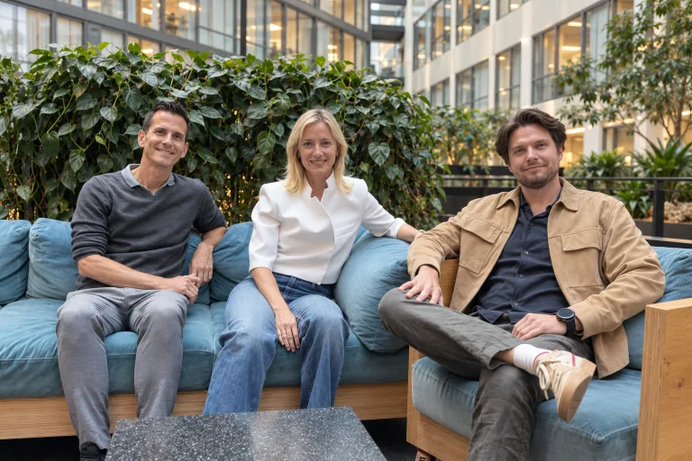 The three Sasha founders sitting together on a blue sofa.
